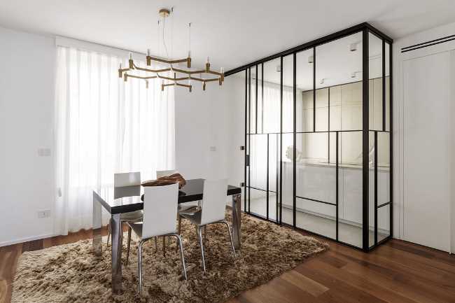 Cuisine-véranda et boiseries fluides dans un appartement turinois